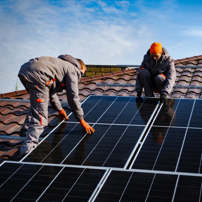 Two men installing solar panels